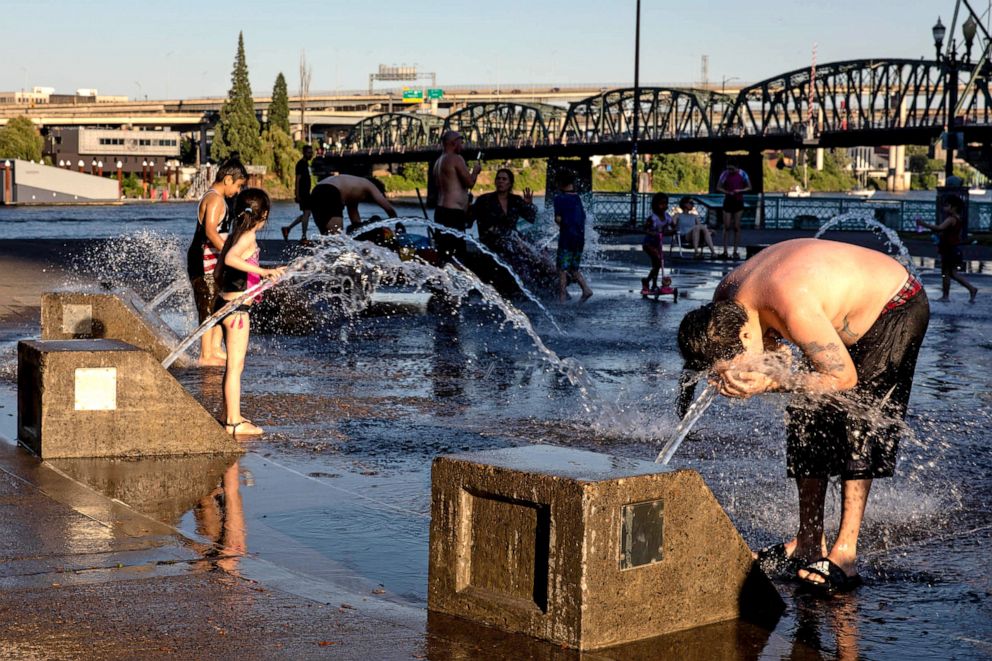 PHOTO: Residents cool off in a riverfront water fountain during a heatwave in Portland, Ore., June 26, 2021.