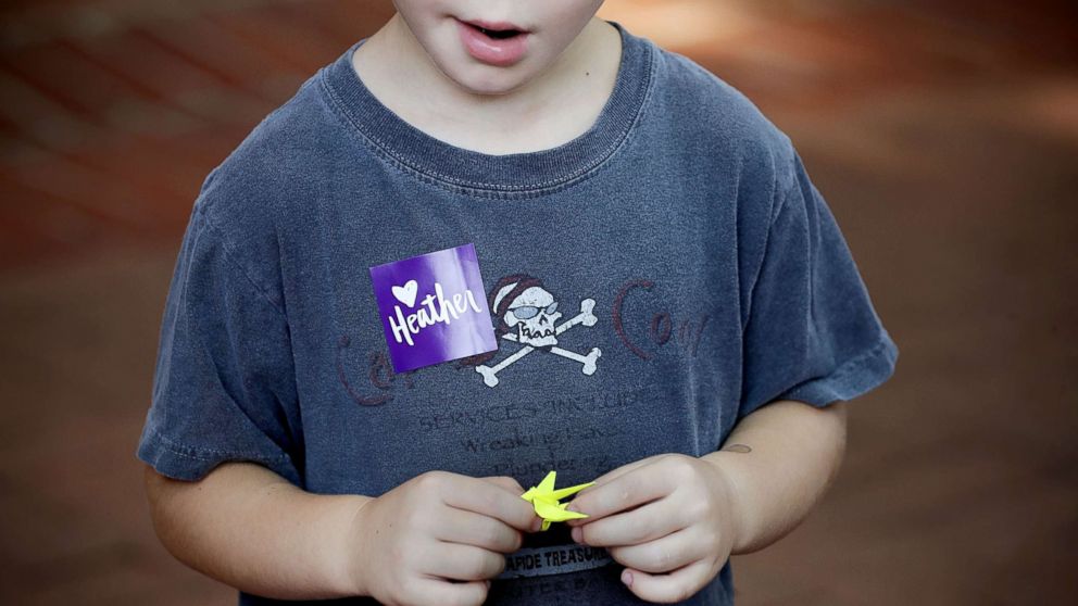 PHOTO: A boy holds a paper crane while waiting in line for the memorial service for Heather Heyer, who was killed when a car slammed into a crowd of people protesting against a white supremacist rally, Aug. 16, 2017 in Charlottesville, Va.