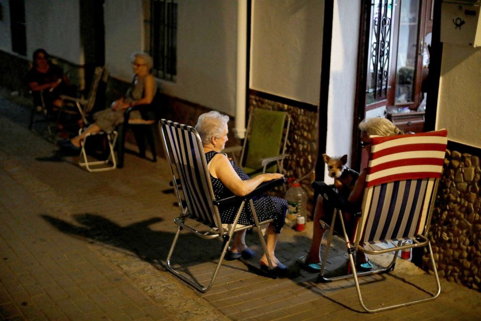PHOTO: Neighbors chat as they sit outside their houses to avoid the heat at night, as a heatwave hits Algar, Spain Aug. 12, 2021.