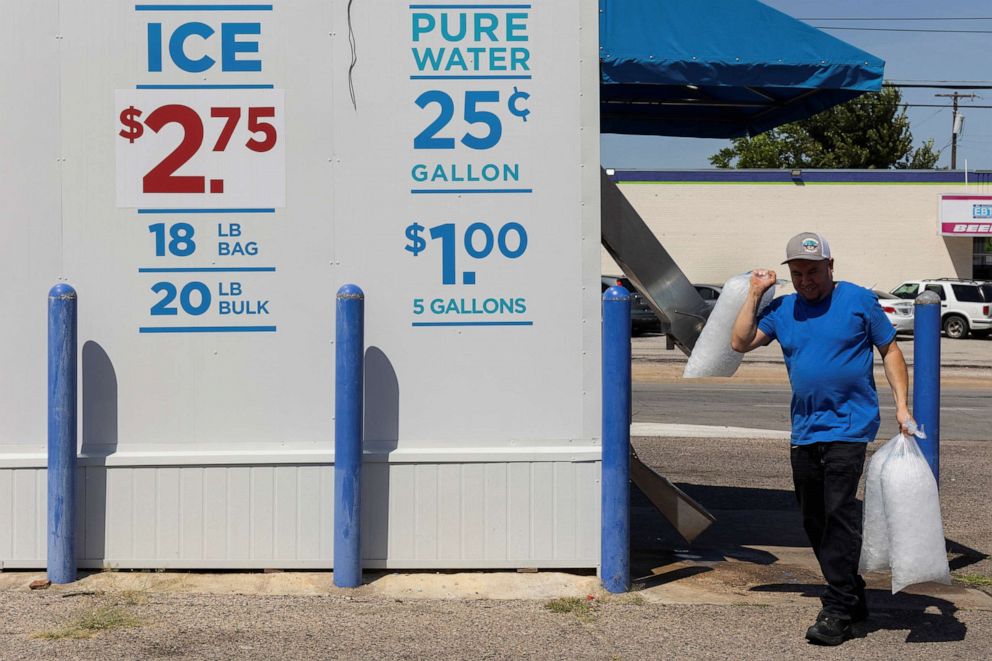 PHOTO: Jose Luis carries three bags of ice he purchased back to his workplace during a heatwave with expected temperatures of 102 in Dallas, Texas, June 12, 2022.