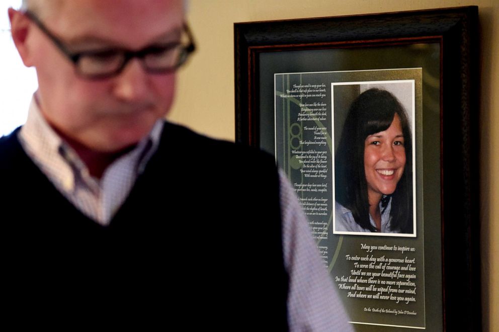 PHOTO: In this May 1, 2019, file photo, John Erickson walks by a photo of his daughter, Heidi Firkus, alongside a poem "On the Death of the Beloved," on the living room wall in his Falcon Heights, Minn. home.