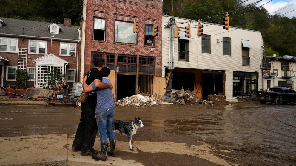 PHOTO: Resident Anne Schneider hugs her friend Eddy Sampson as they survey damage left in the wake of Hurricane Helene, Oct. 1, 2024, in Marshall, N.C. 