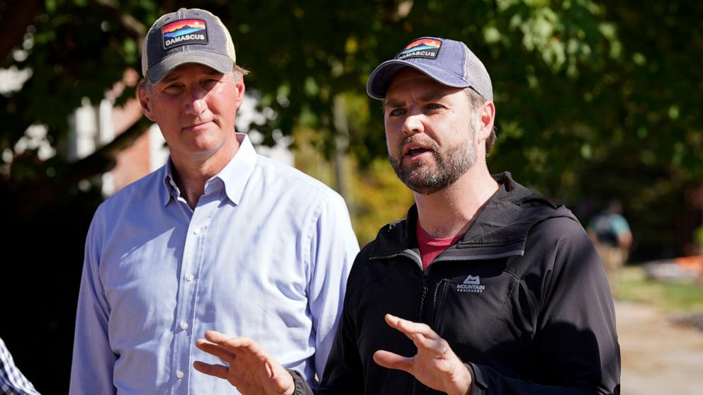 PHOTO: Republican vice presidential nominee Sen. JD Vance talks as Virginia Gov. Glenn Youngkin listens as he visits areas impacted by Hurricane Helene in Damascus, Va., Oct. 3, 2024. 