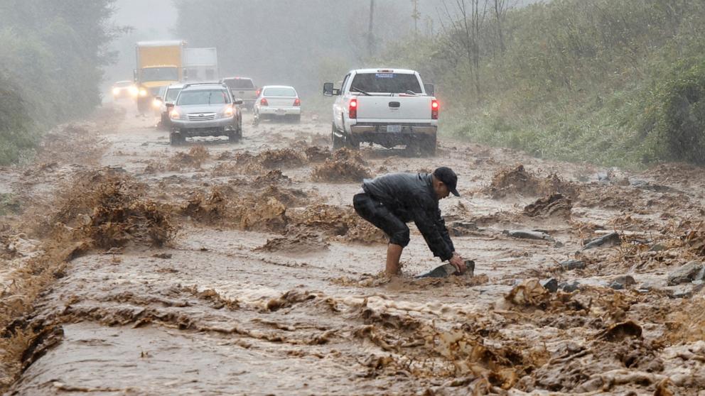 PHOTO: A local resident clears boulders that were swept by fast-flowing waters onto a stretch of flooded road as Tropical Storm Helene strikes, on the outskirts of Boone, North Carolina, Sept. 27, 2024. 