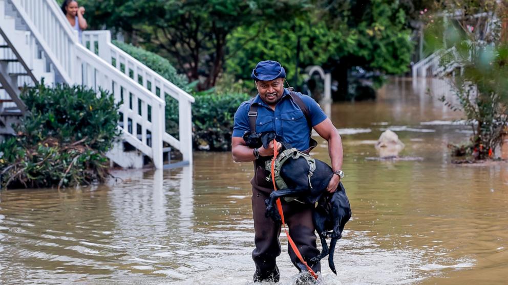 PHOTO: Television reporter Ryan Young helps a Peachtree Park Apartments resident with her dog after flood waters from Peachtree Creek inundated the complex in the aftermath of Tropical Storm Helene in Atlanta, Georgia, Sept. 27, 2024. 