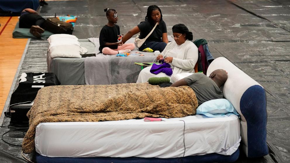 PHOTO: Sharonda and Victor Davis, of Tallahassee, sit with their children Victoria and Amaya inside a hurricane evacuation shelter at Fairview Middle School, ahead of Hurricane Helene, in Leon County, Fla., Sept. 26, 2024.