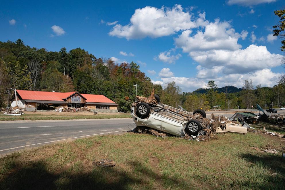 PHOTO: An upside-down car covered by pieces of tree is left on the side of a road in the aftermath of Hurricane Helene in Burnsville, North Carolina, on October 5, 2024.