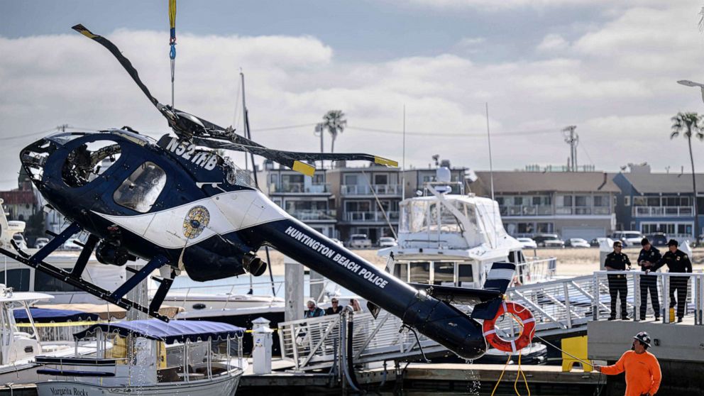 PHOTO: A Huntington Beach Police helicopter is lifted out of the water in Newport Beach, Calif., Feb. 20, 2022.