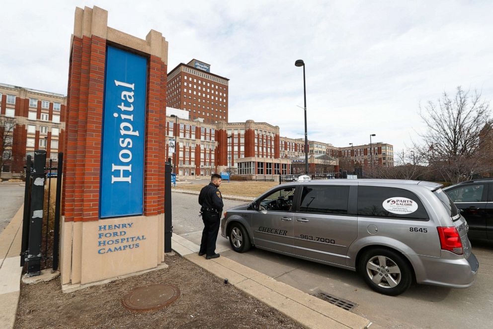 PHOTO: A security guard screens visitors before entering Henry Ford Hospital in Detroit, Michigan, on March 16, 2020.
