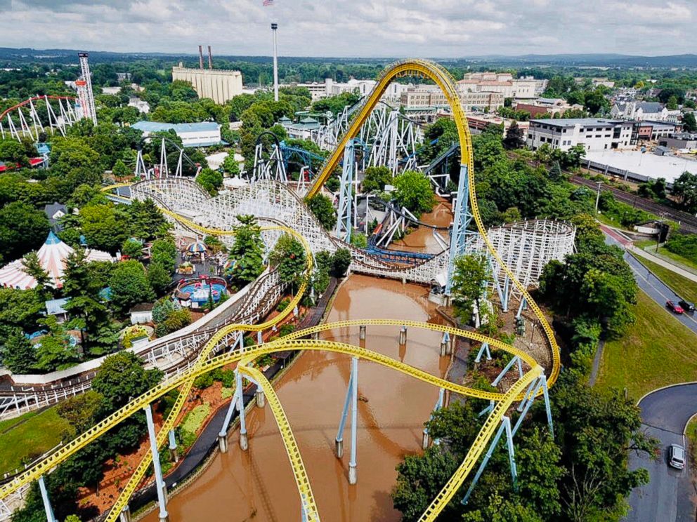 PHOTO: In this July 23, 2018, aerial image provided by The Wyse Choice photography in Hershey, Penn., muddy brown floodwaters in Spring Creek flow beneath the Skyrush roller coaster and the Comet roller coaster at the Hersheypark theme park.