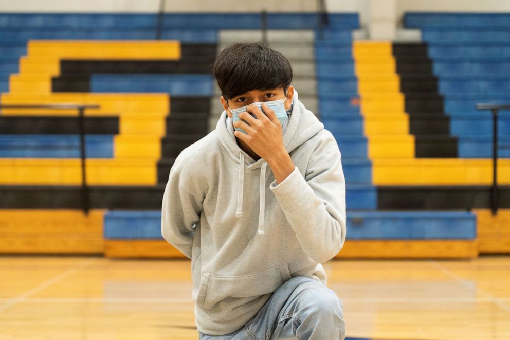 PHOTO: A sophomore student at Louise High School Antonio Martinez, 15, also a cross country runner,  wears a mask as he poses, during the COVID-19 pandemic in Louise, Texas, Nov. 20, 2020.