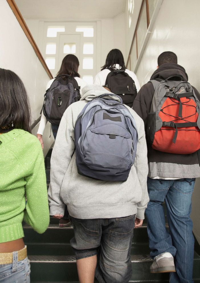 PHOTO: students walking up stairs in a high school 