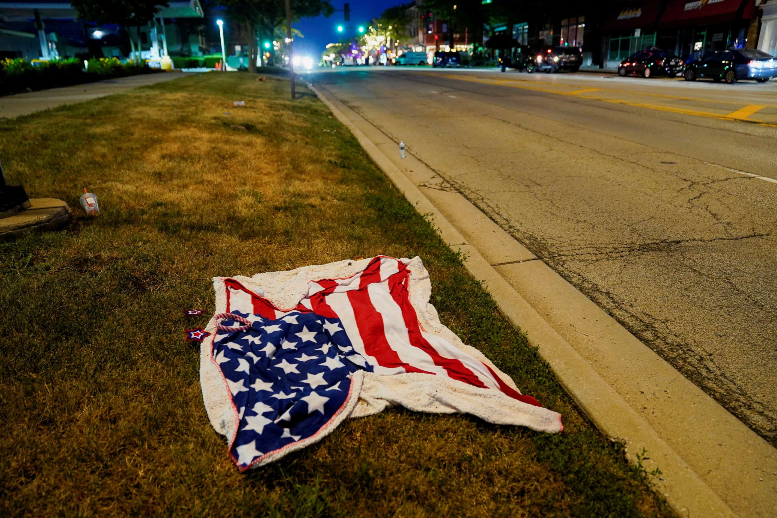 PHOTO: An American flag blanket is seen abandoned along the parade route after a mass shooting at a Fourth of July parade in the Chicago suburb of Highland Park, Illinois, on July 4, 2022.
