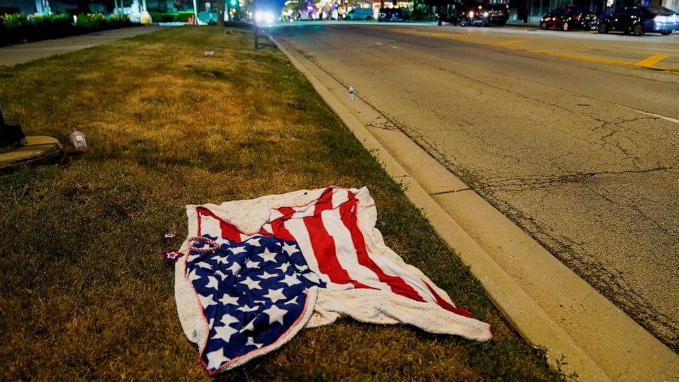 عکس: یک پتوی پرچم آمریکا پس از تیراندازی دسته جمعی در رژه چهارم ژوئیه در شیکاگو، حومه ایلینوی در هایلند پارک، در 4 ژوئیه 2022 در جاده رژه رها شده است.