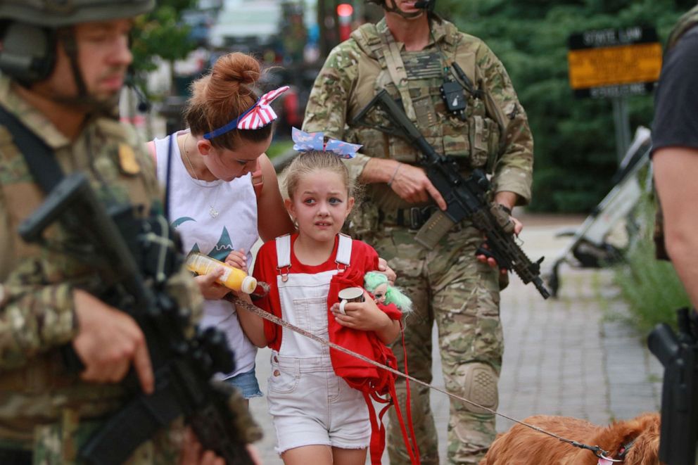 PHOTO: Law enforcement escort a family away from the scene of a deadly shooting at a Fourth of July parade on July 4, 2022 in Highland Park, Ill.