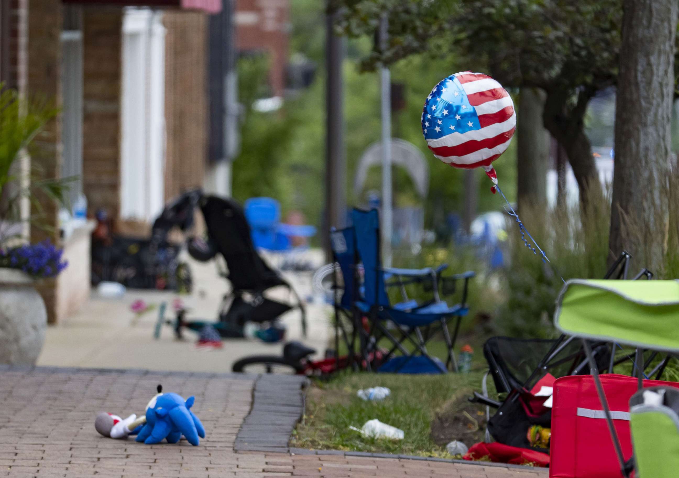 PHOTO: Chairs, bicycles, strollers and balloons were left behind at the scene of a mass shooting on the Fourth of July parade route along Central Avenue in Highland Park, Ill., July 4, 2022. 