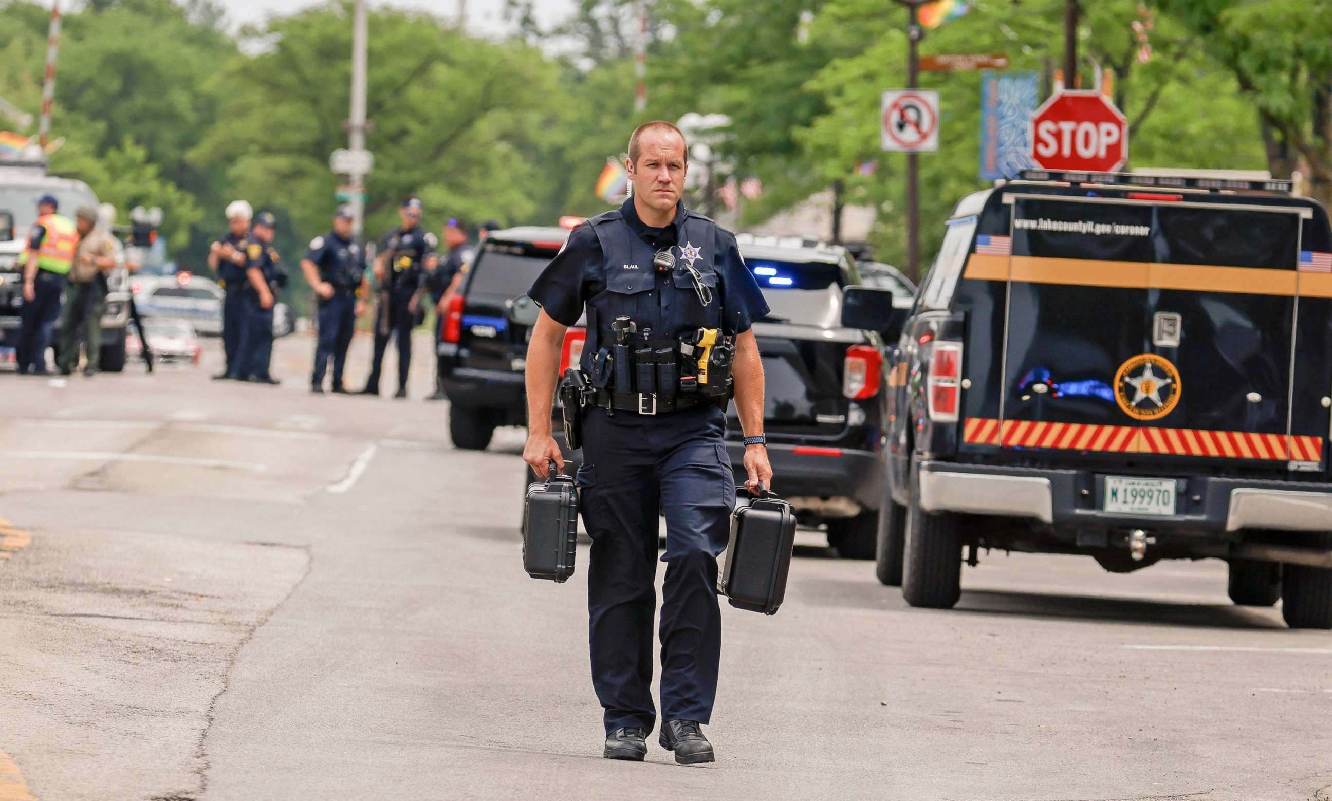 PHOTO: A police officer  investigates the scene as he walks in downtown Highland Park, Ill., a suburb of Chicago, Monday, July 4, 2022, where a mass shooting took place at a Highland Park Fourth of July parade.