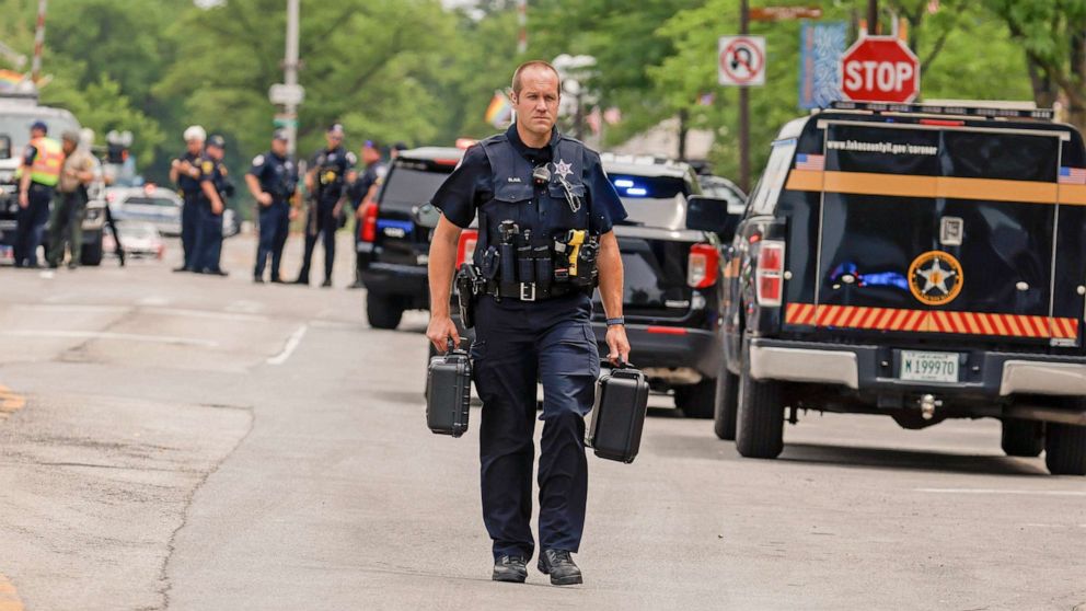 PHOTO: A police officer investigates the scene as he walks in downtown Highland Park, Ill., A suburb of Chicago, Monday, July 4, 2022, where a mass shooting took place at a Highland Park Fourth of July parade.