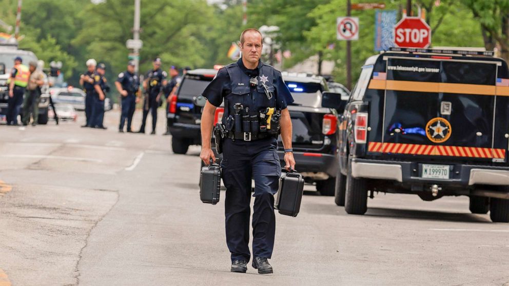 PHOTO: A police officer investigates the scene as he walks in downtown Highland Park, Ill., a suburb of Chicago, Monday, July 4, 2022, where a mass shooting took place at a Highland Park Fourth of July parade.