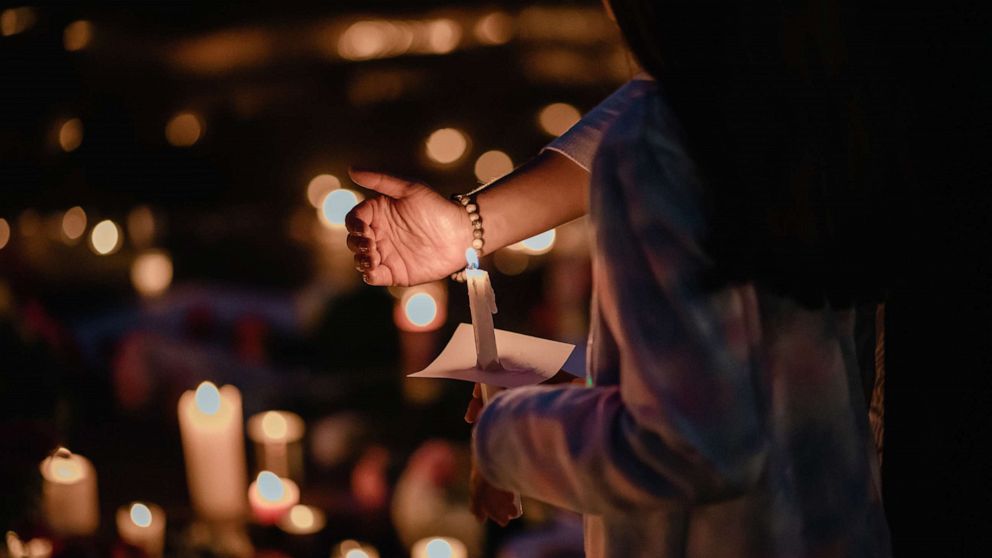 PHOTO: Mourners gather for a candlelight vigil at a makeshift memorial to the victims of the Fourth of July shooting rampage in Highland Park, Ill., July 5, 2022. 