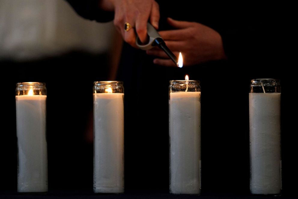 PHOTO: A event participant lights a memorial candle during an event of unity and healing at the Central Avenue Synagogue-Chabad in Highland Park for the victims of Monday's Highland Park's Fourth of July parade in Highland Park, Ill., July 7, 2022.