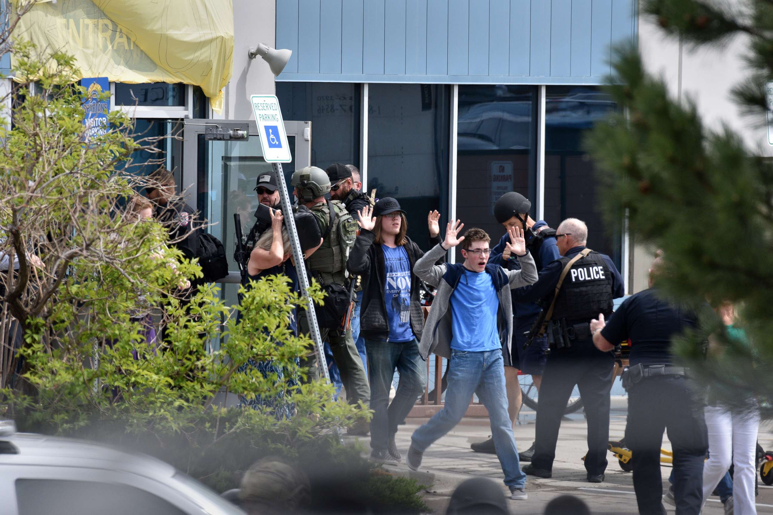 PHOTO: Students and teachers raise their hands as the exit the scene of a shooting at the STEM School Highlands Ranch on May 7, 2019 in Highlands Ranch, Colo.