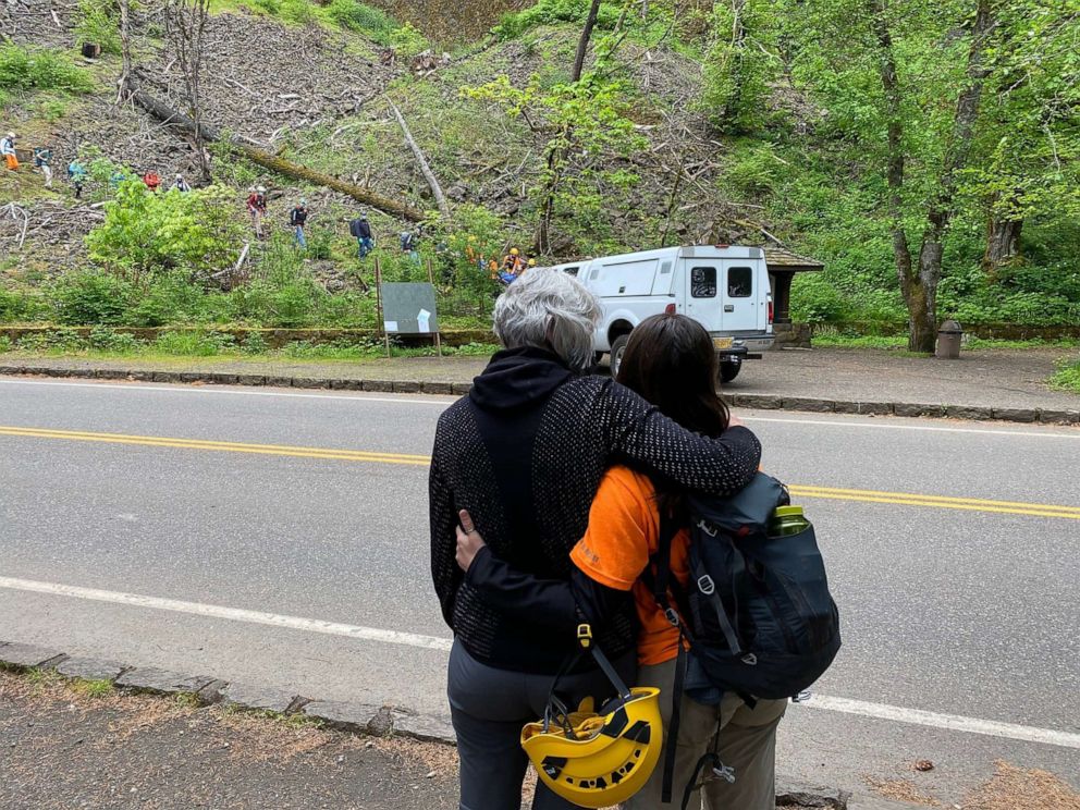 PHOTO: A relative is consoled by a search and rescue member as missing Portland hiker Joe Dean is carried down to the command post after locating him on May 10, 2021, near the Horsetail Falls Trail in Oregon.