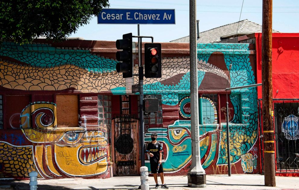 PHOTO: A man waits to cross the street in the largely Latino neighborhood of East Los Angeles, Aug. 7, 2020, in Los Angeles.