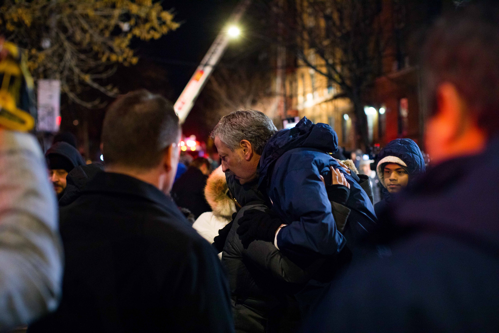 New York City Mayor Bill de Blasio hugs a resident of the apartment building where 12 people died in the Bronx on Dec. 28, 2017.
