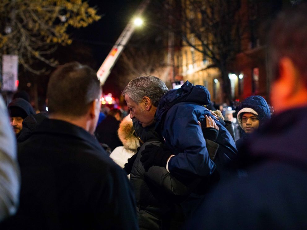 New York City Mayor Bill de Blasio hugs a resident of the apartment building where 12 people died in the Bronx on Dec. 28, 2017.