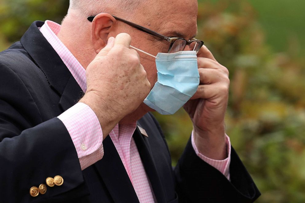 PHOTO: Maryland Governor Larry Hogan replaces his surgical mask after talking to reporters during a news briefing in front of the Maryland State House, April 17, 2020 in Annapolis, Md.