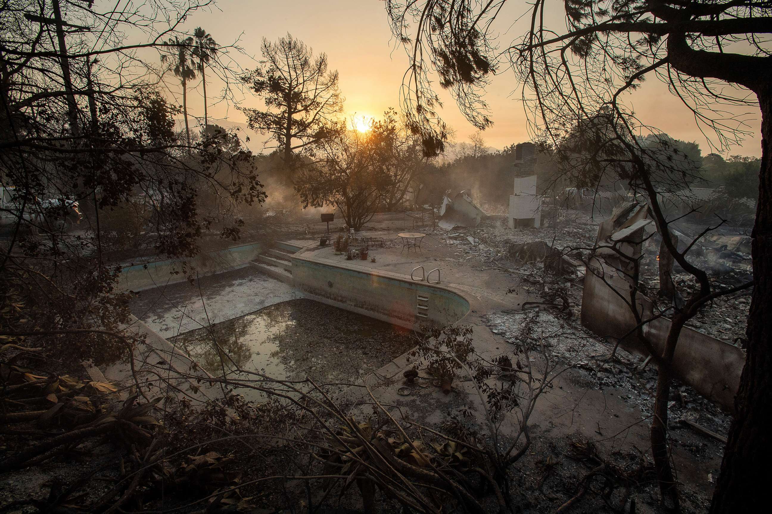 PHOTO: The sun rises behind a home leveled by the Holiday fire in Goleta, Calif., on Saturday, July 7, 2018.