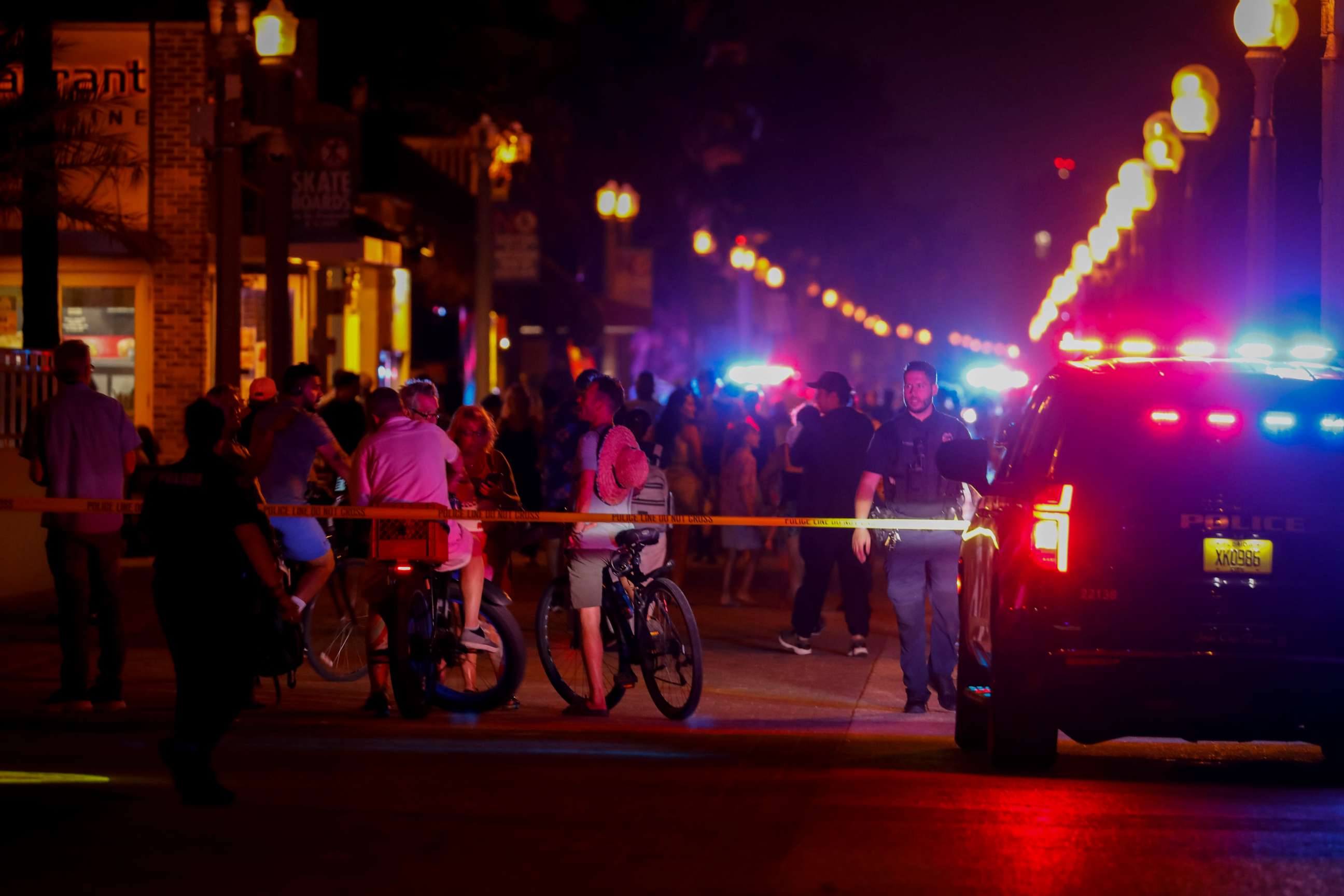 PHOTO: Beachgoers are seen next to law enforcement officers on a crime scene as they respond to a shooting at Hollywood Beach on May 29, 2023 in Hollywood, Florida.