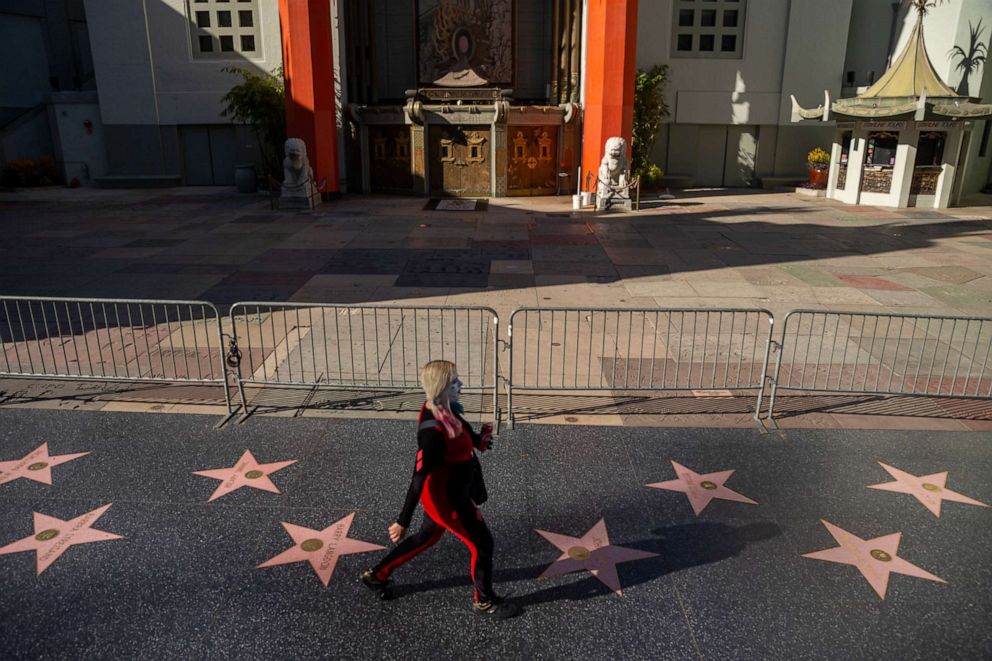 PHOTO: A pedestrian walks past the closed TCL Chinese Theatre, a normally packed tourist destination on Hollywood Boulevard in Los Angeles, Tuesday, March 24, 2020. 
