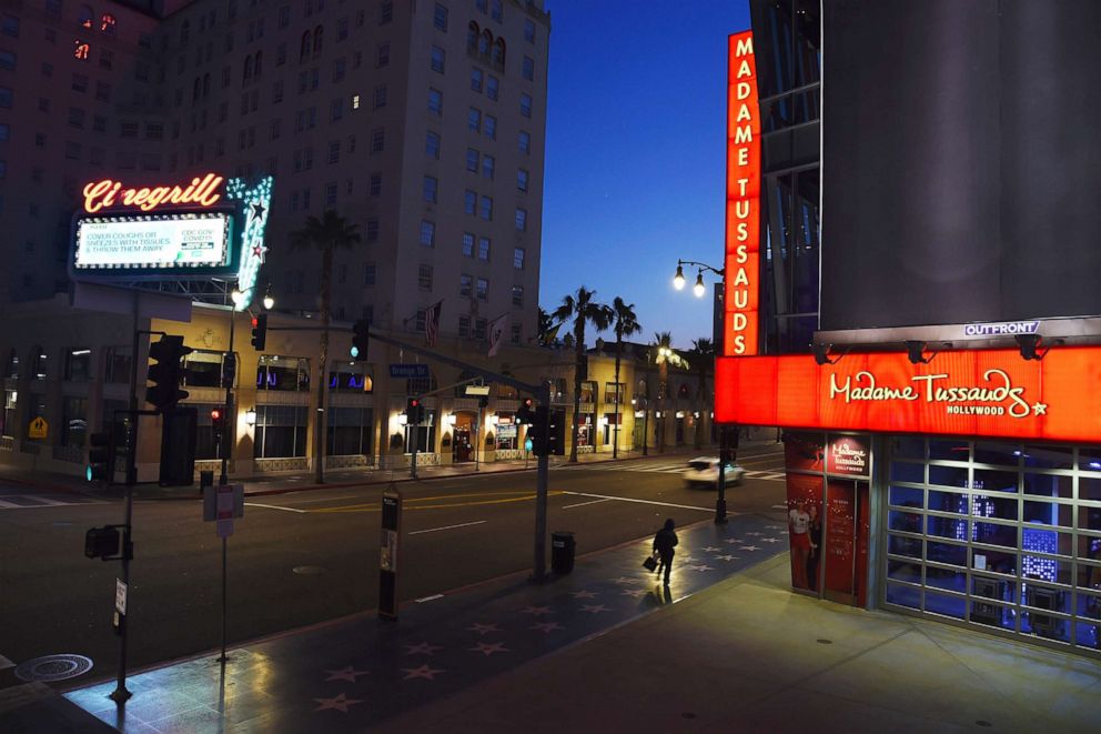 PHOTO: A lone pedestrian passes by Madame Tussauds wax museum on the largely empty Hollywood Boulevard as shutdown orders continue in California due to the coronavirus pandemic, May 11, 2020, in Los Angeles.