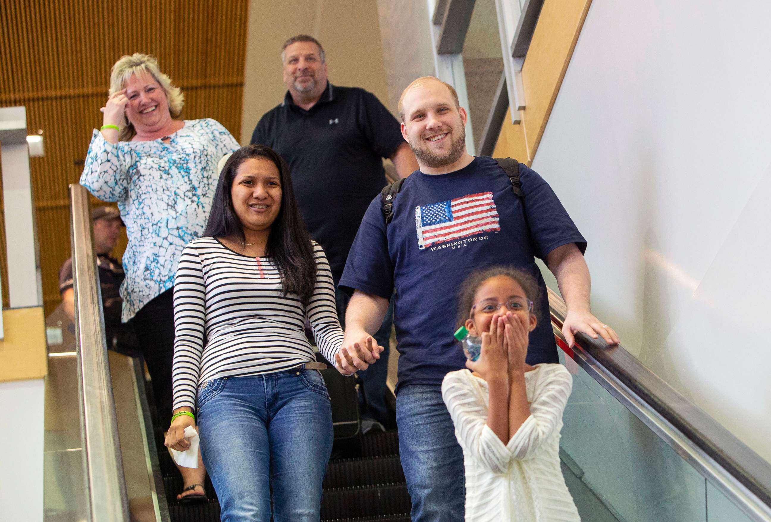 PHOTO: Josh Holt, right, returns with wife, Thamara Caleno, left, and daughter, Marian, bottom, to a crowd of friends and family in Salt Lake City after receiving medical care and visiting President Donald Trump in Washington, May 28, 2018.
