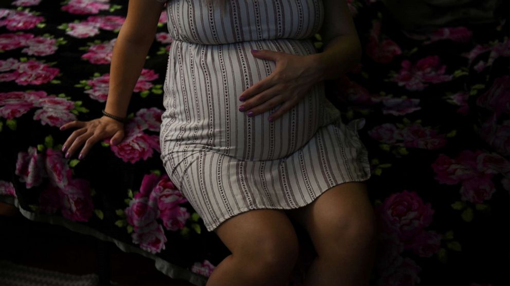 PHOTO: Nancy Pedroza touches her stomach at her parent's house where she currently lives with her partner and father to their unborn child, during the coronavirus disease outbreak, in Fort Worth, Texas, April 5, 2020.