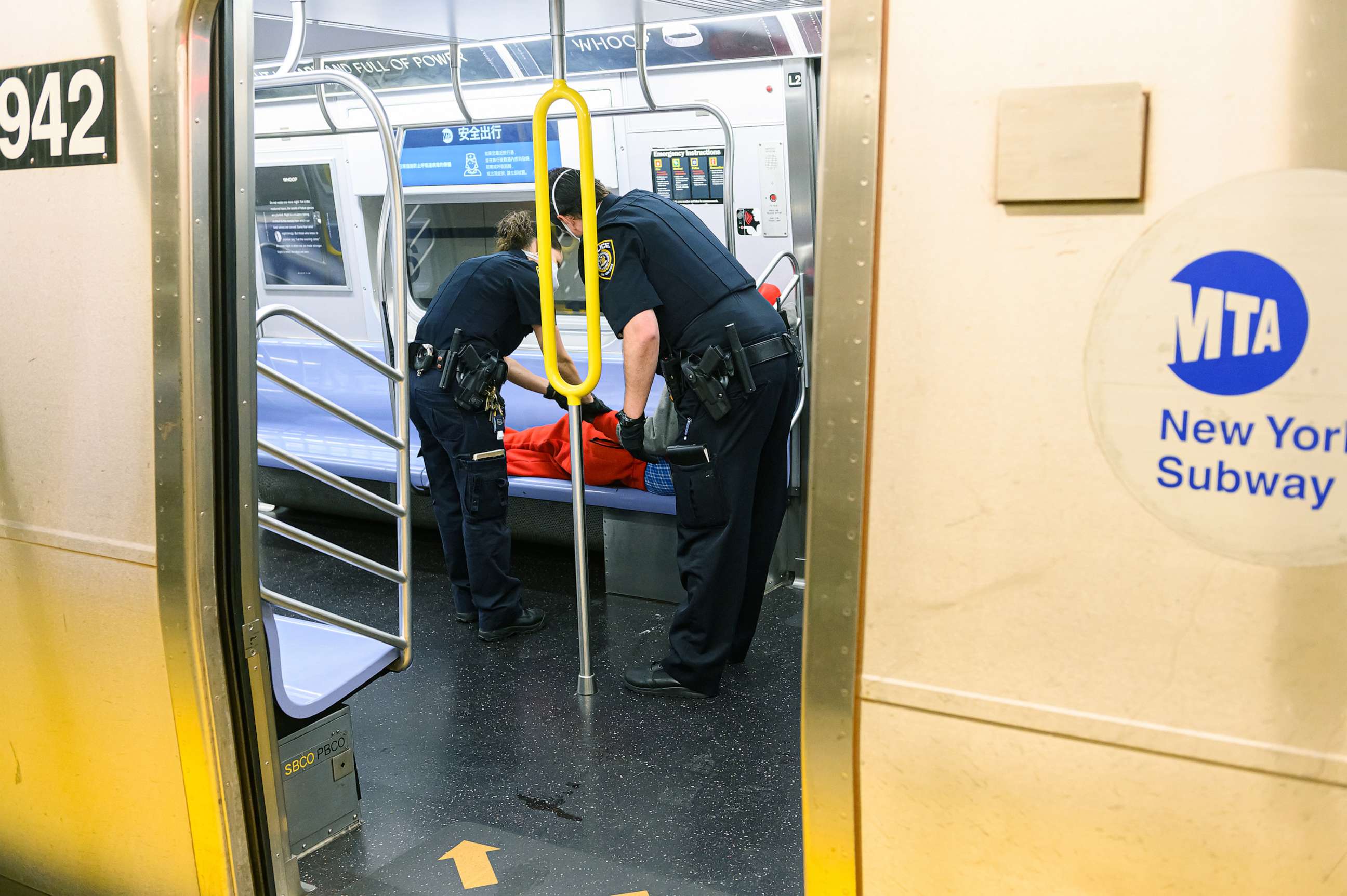 PHOTO: NYPD officers escort an individual sleeping on train, May 23, 2020, in New York.