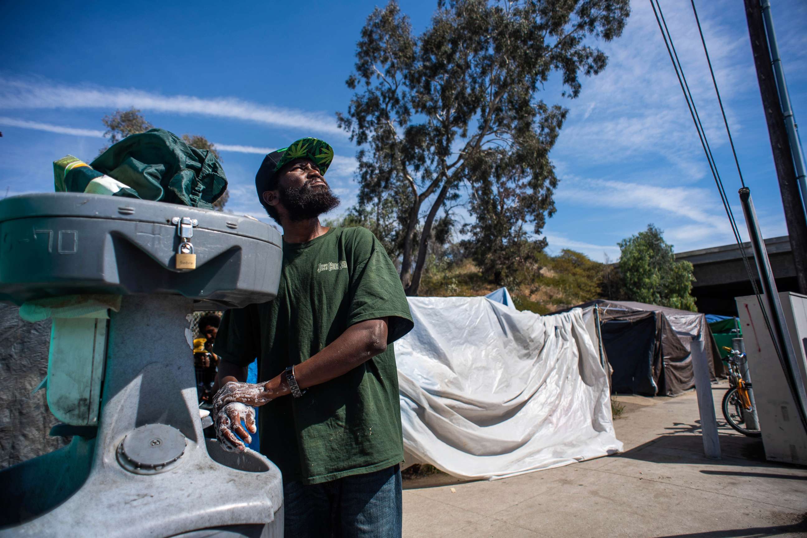 PHOTO: A resident of a homeless encampment in Pacoima, Calif., washes his hands in a portable washing station on Thursday, March 5, 2020.