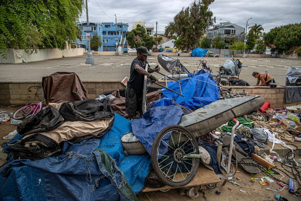 PHOTO: Houseless people pack up their belongings before clean-up by Los Angeles City sanitation of an encampment along 200 block of S. Venice Blvd., Los Angeles, June 7, 2023.