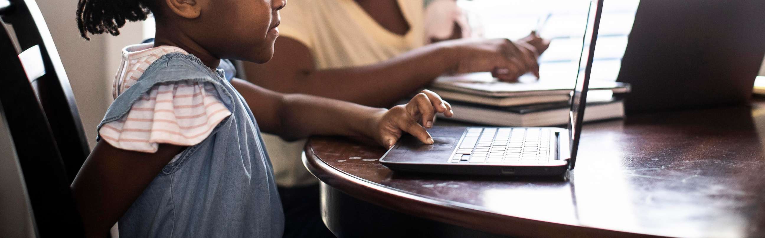 PHOTO: A woman and child work on computers in an undated stock photo.