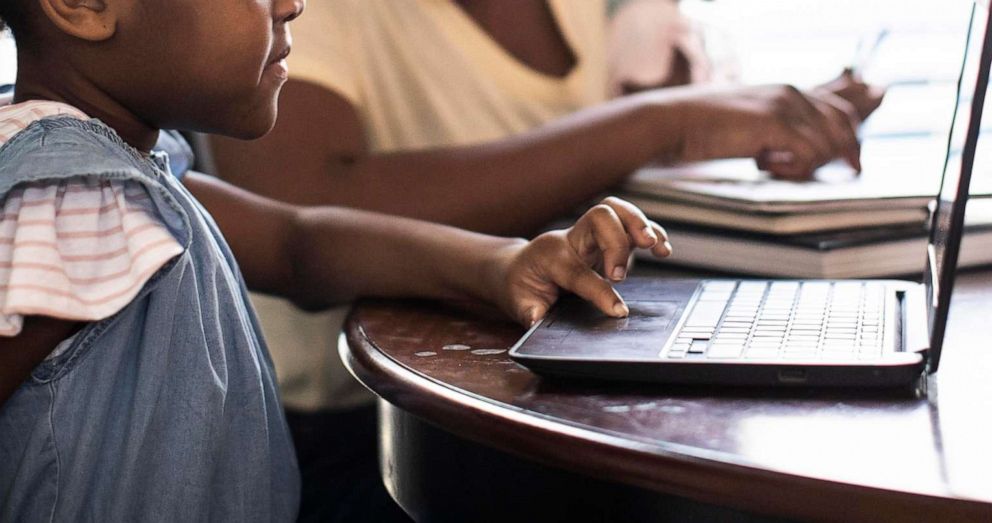 PHOTO: A woman and child work on computers in an undated stock photo.