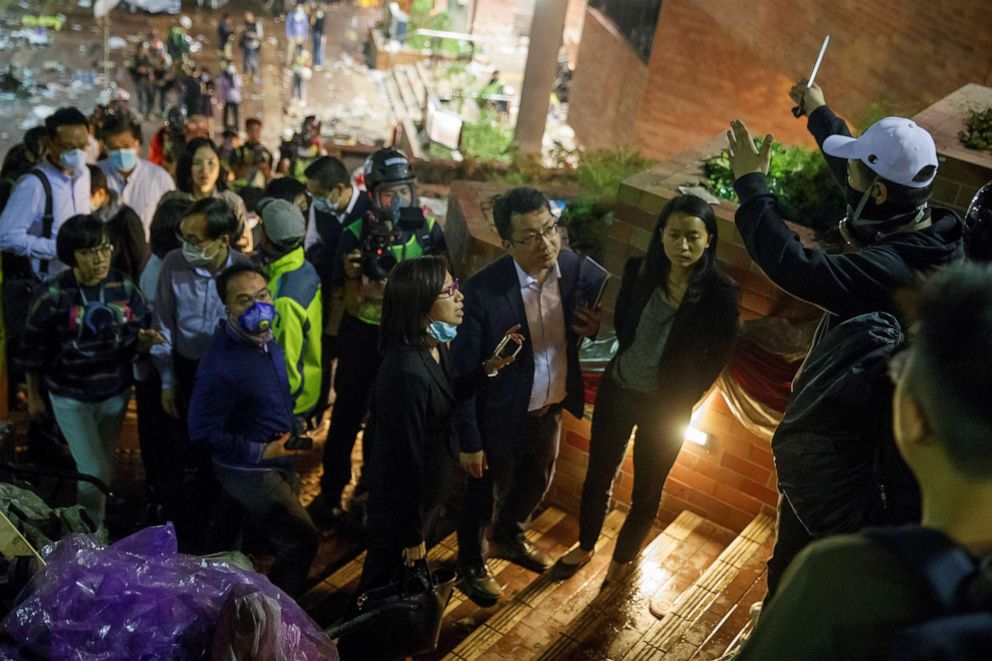 PHOTO: Teachers and relatives negotiate with protesters about the surrender of younger students from the occupied campus of the Hong Kong Polytechnic University that is surrounded by police in Hong Kong, Nov. 19, 2019.