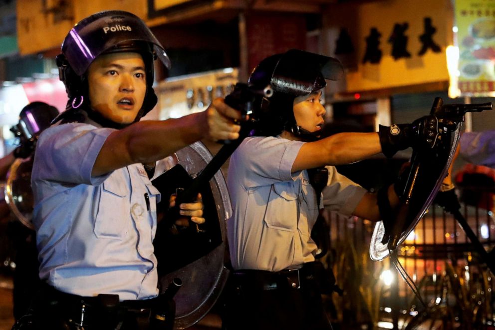 PHOTO: Police officers point their guns towards anti-extradition bill protesters after a clash, at Tsuen Wan, in Hong Kong, China, August 25, 2019.
