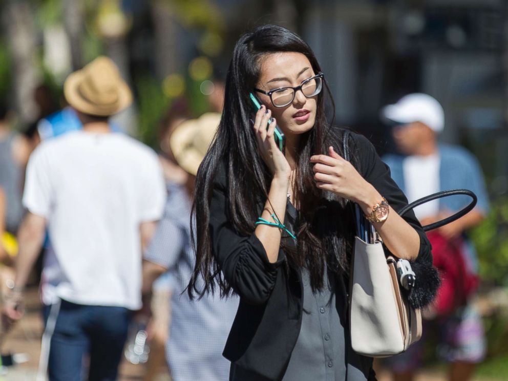 PHOTO: A pedestrian crosses Kalakaua Avenue talking on her cell phone, Oct. 24, 2017 in Honolulu.