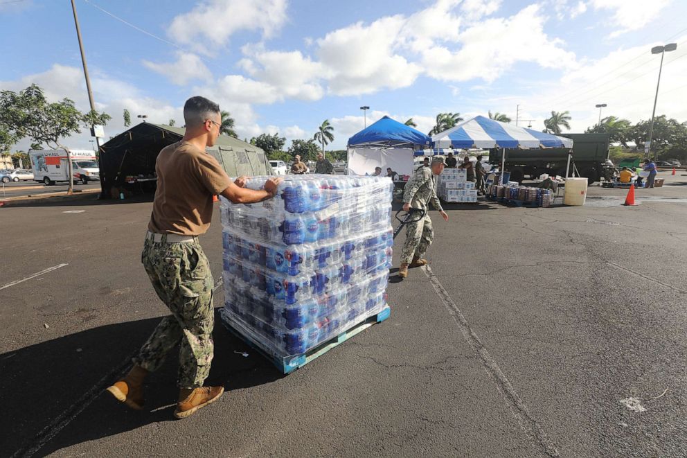 PHOTO: In this Dec. 9, 2021, file photo, Sailors and Marines assigned to various commands hand out fresh water at the Joint Base Pearl Harbor-Hickam (JBPHH) Navy Exchange Mall parking lot in Honolulu.