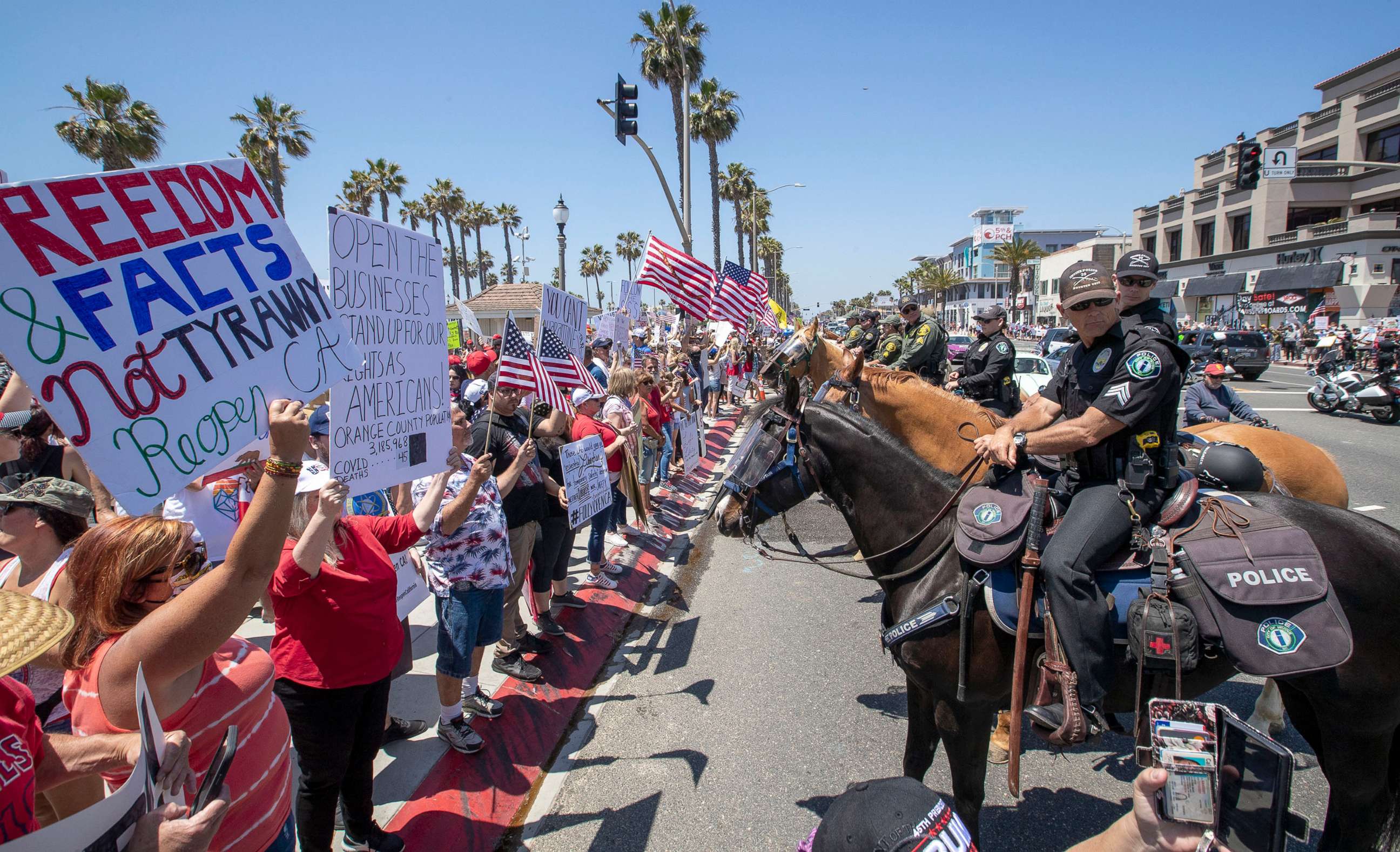 PHOTO: Mounted police line up to keep protesters on the sidewalk during a rally to call on California Governor Gavin Newsom to relax the state's stay-at-home orders under COVID-19 in Huntington Beach, Calif., May 1, 2020.