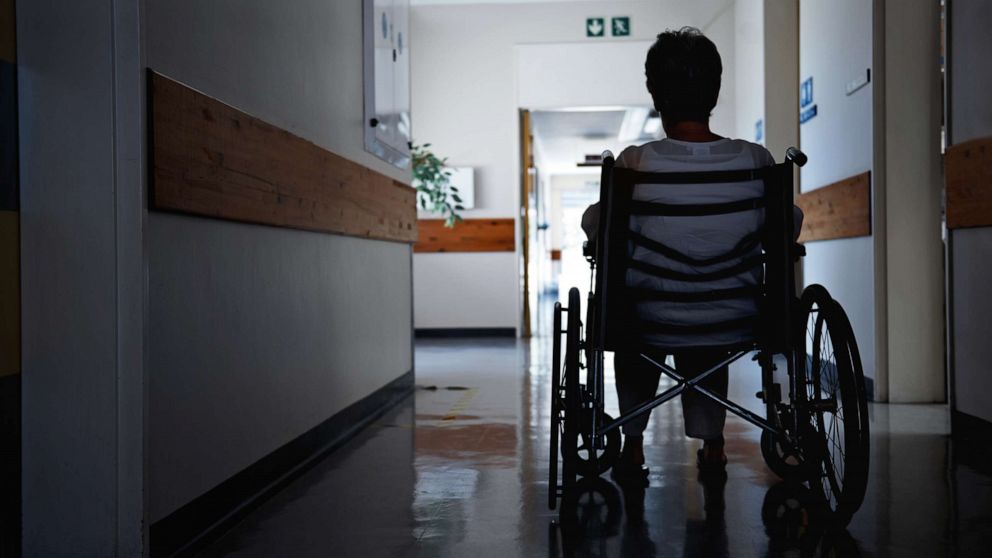 PHOTO: A woman in a wheelchair in what looks like a nursing home. 