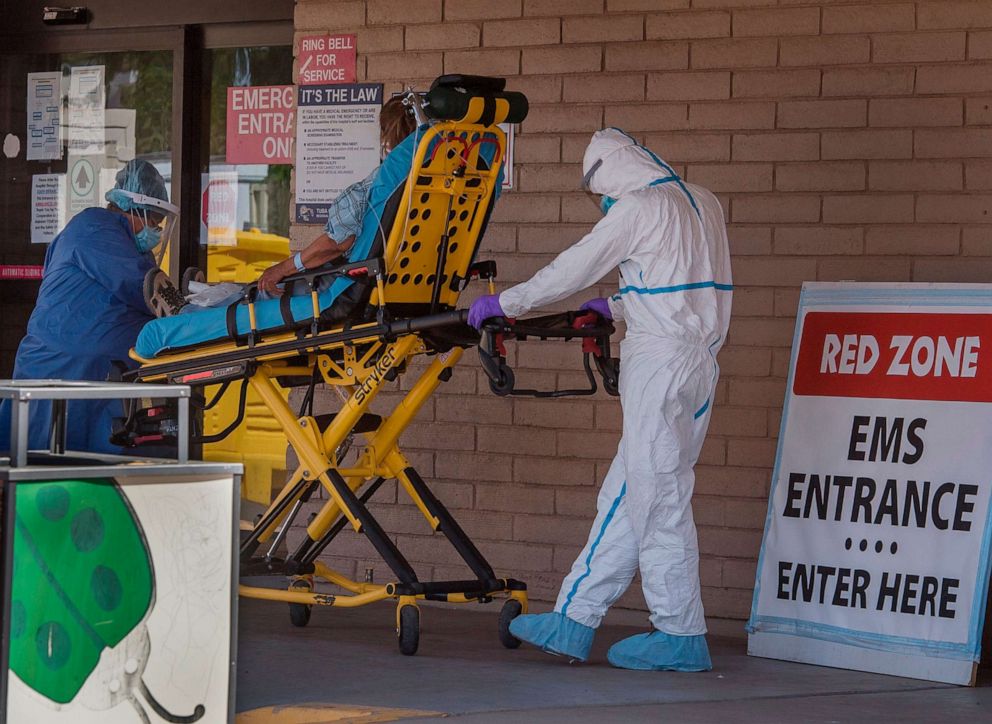 PHOTO: A patient is taken from an ambulance to the emergency room of a hospital in the Navajo Nation town of Tuba City during the 57-hour curfew, imposed to try to stop the spread of the Covid-19 virus through the Navajo Nation, in Arizona.
