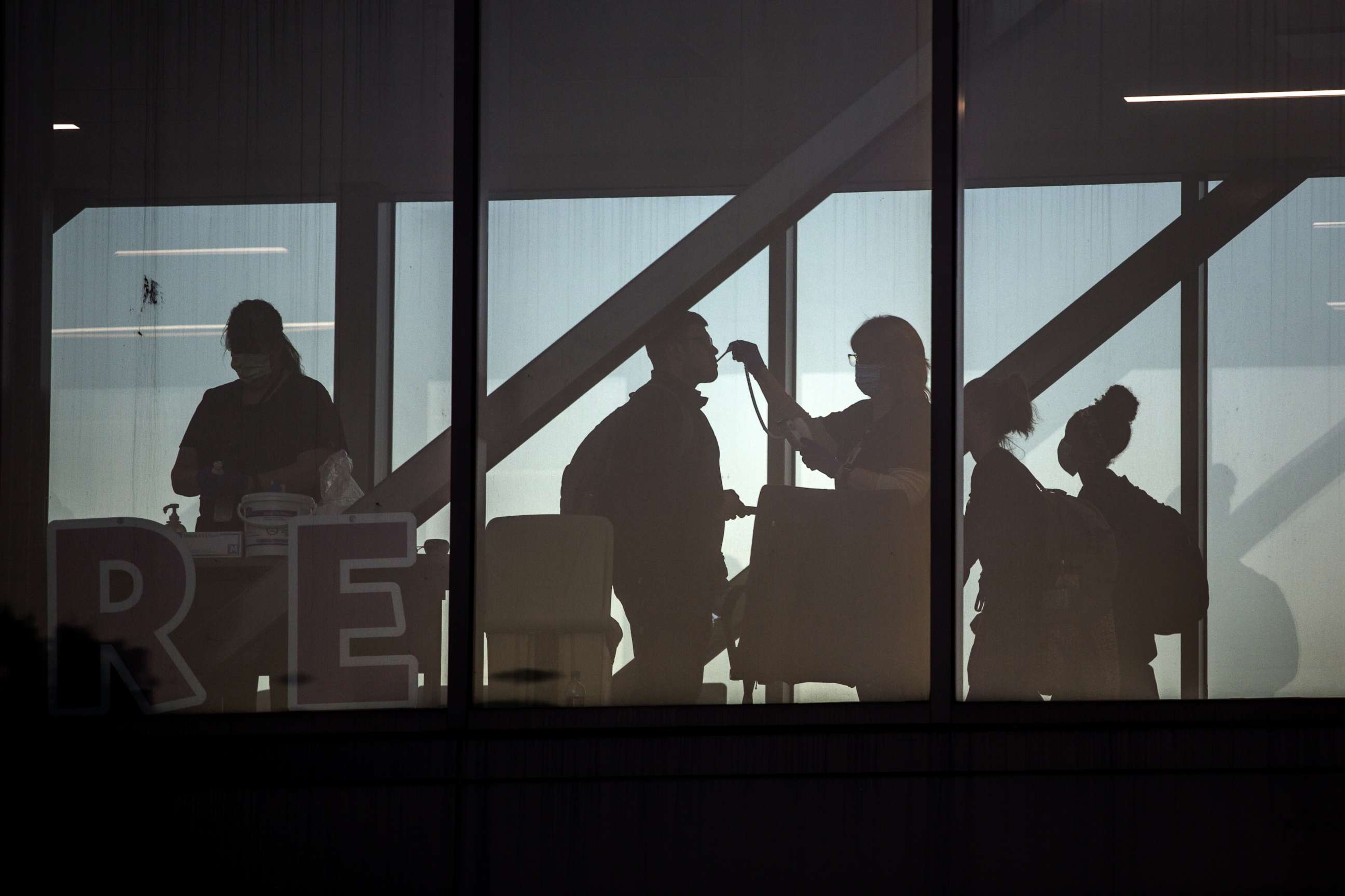 PHOTO: Hospital workers check temperatures of coworkers at a pedestrian walkway at Dell Seton Medical Center at the University of Texas in Austin, Texas, April 13, 2020.